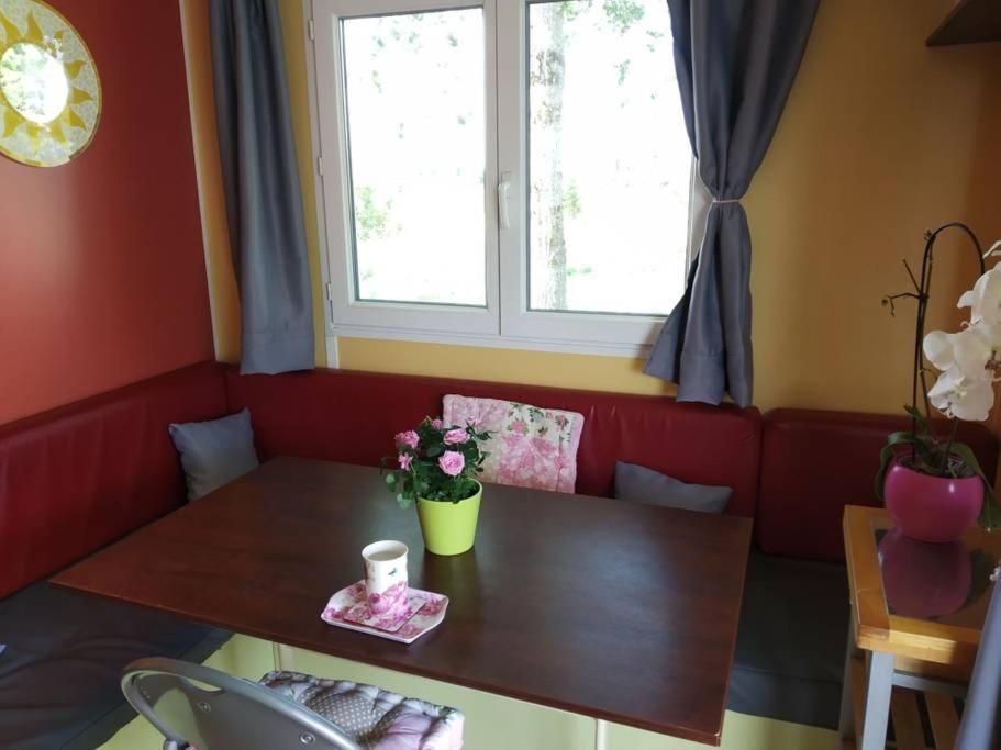 un salon avec une table et une fenêtre dans l'établissement Cottage flottant Saint Jean de Losne option jacuzzi, à Saint-Jean-de-Losne 8 autres photos