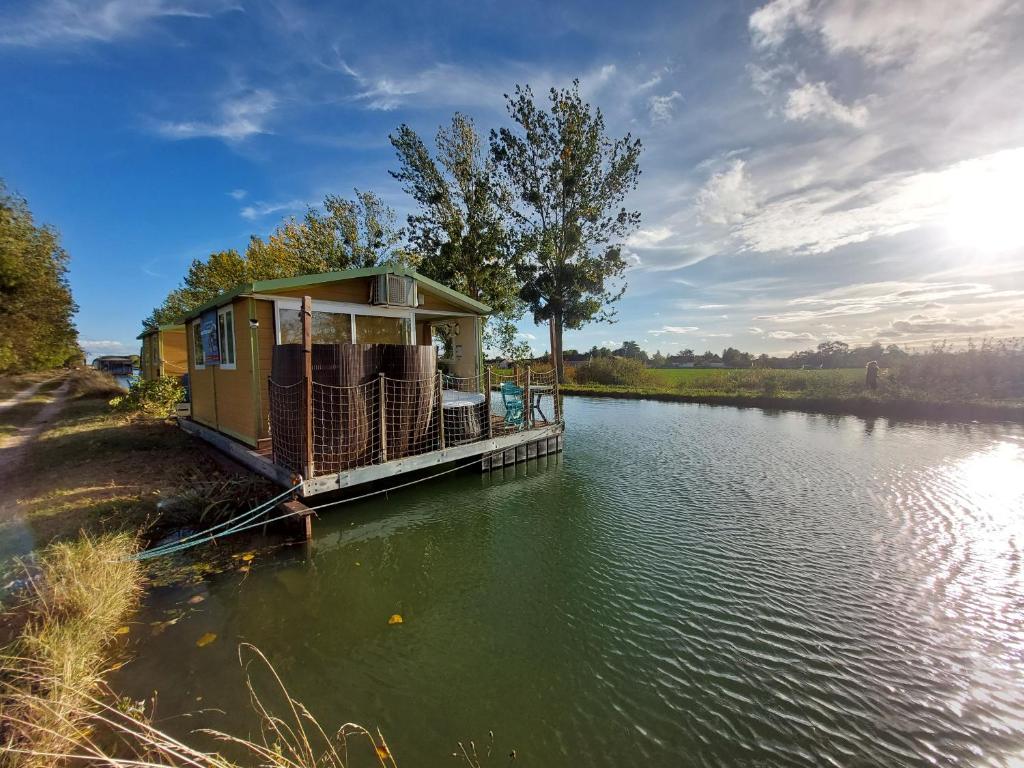 une maison sur un quai sur un plan d'eau dans l'établissement Cottage flottant terrasse jacuzzi option aux Portes de Dijon, à Ouges