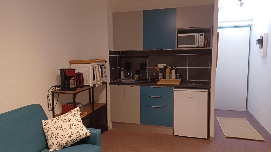 une petite cuisine avec un micro-ondes et un réfrigérateur dans l'établissement Studio PRAPOUTEL, à Prapoutel