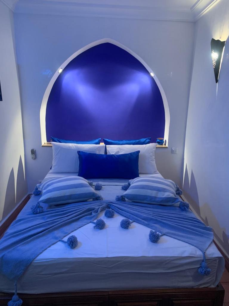 une chambre bleue avec un lit doté d'une tête de lit bleue dans l'établissement Riad Le Roy’s, à Marrakech