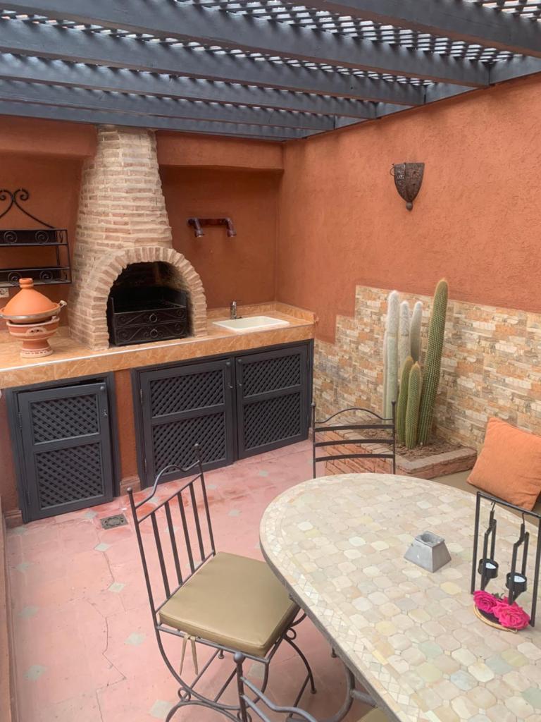 d'une terrasse avec une table et un four à pizza. dans l'établissement Riad Le Roy’s, à Marrakech