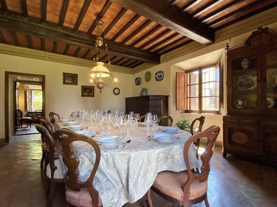 - une salle à manger avec une table et des verres dans l'établissement Tenuta Uzielli an elegant countryside villa, à Monteriggioni
