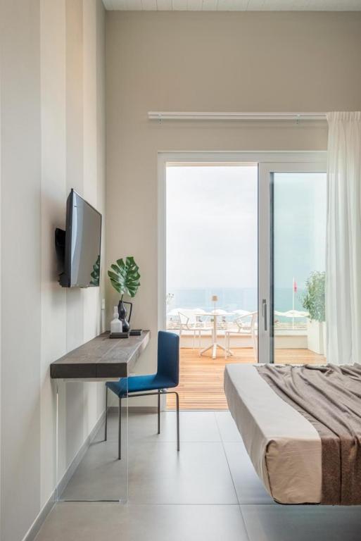 une chambre avec un lit, un bureau et une télévision dans l'établissement Marino1958 RTA, à Numana