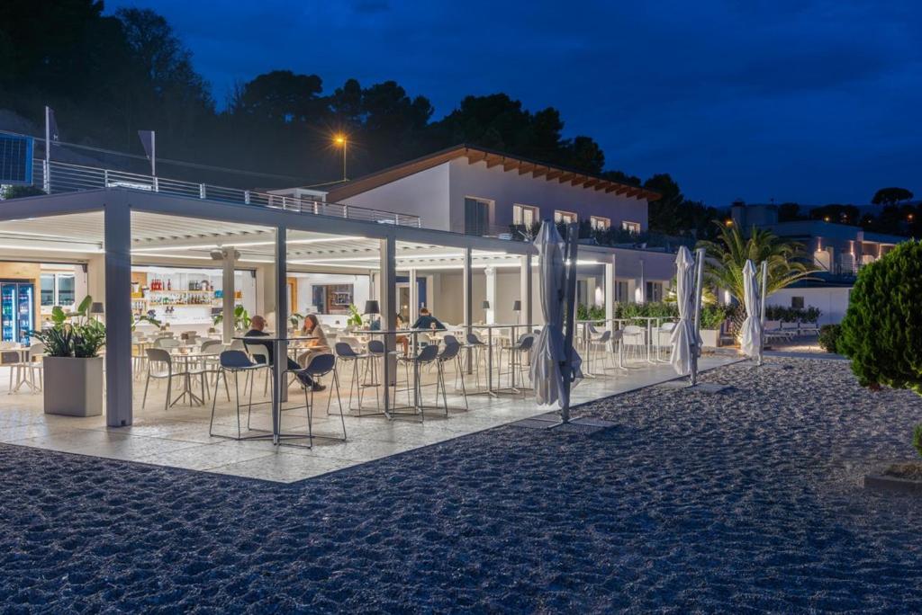 un groupe de chaises et de parasols devant un bâtiment dans l'établissement Marino1958 RTA, à Numana