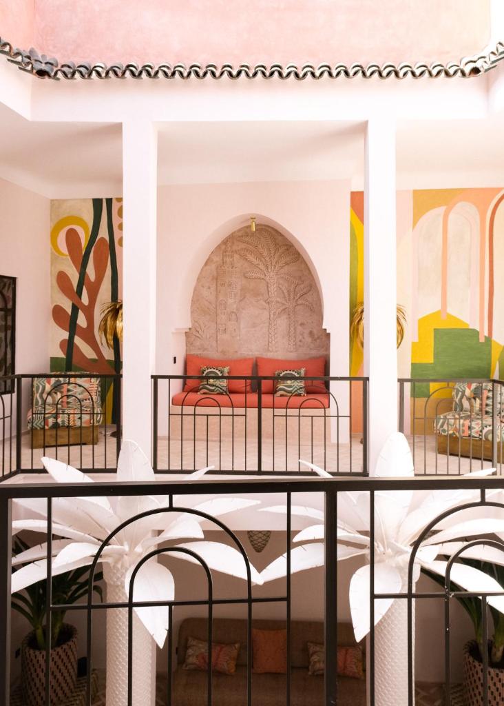 Ce lit se trouve dans un dortoir orné de peintures murales. dans l'établissement Riad Pompon, à Marrakech