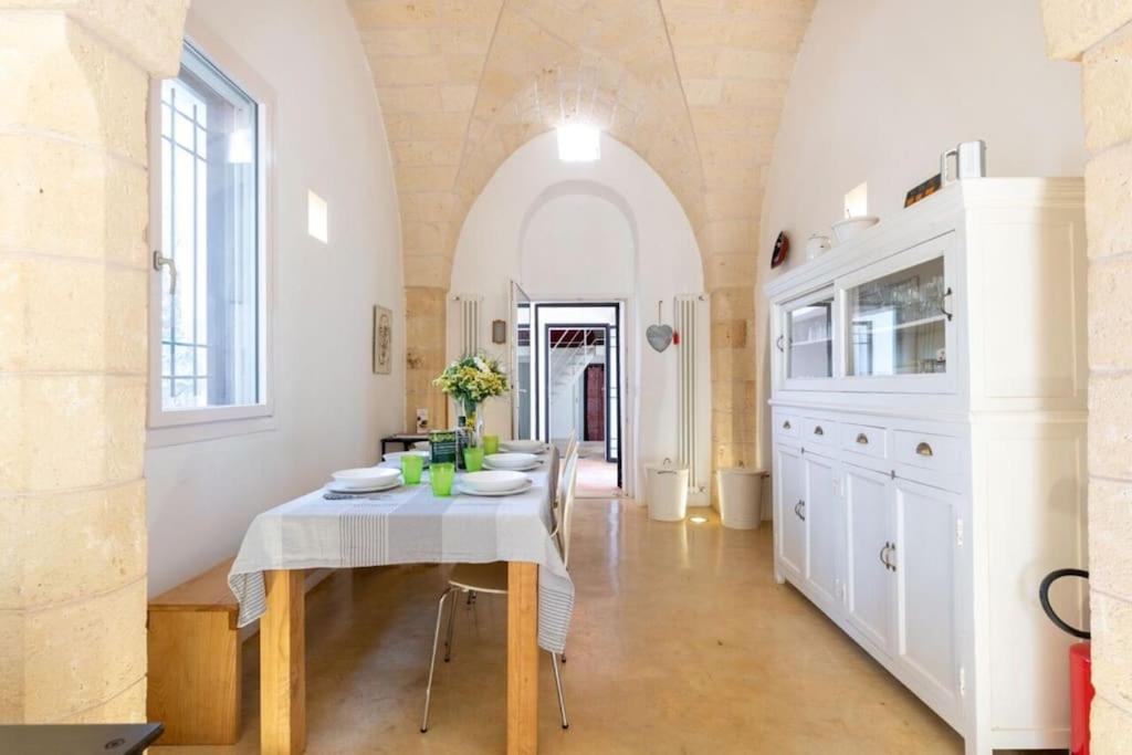 une salle à manger avec une table et une cuisine dans l'établissement Trullo Cristiana, à Latiano