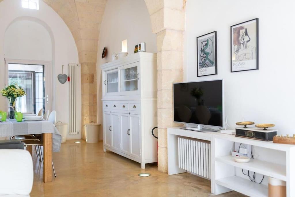 un salon avec une télévision sur un meuble blanc dans l'établissement Trullo Cristiana, à Latiano
