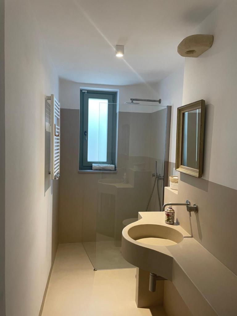 une salle de bain avec toilettes, lavabo et fenêtre dans l'établissement Villa Karbina, à Carovigno