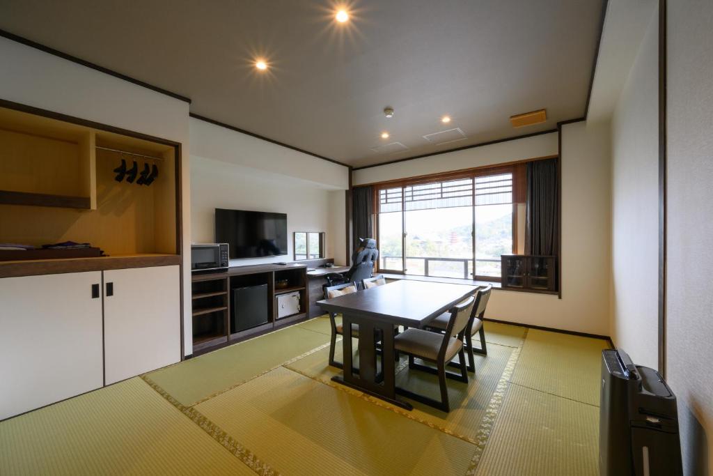 une cuisine et une salle à manger avec une table et des chaises dans l'établissement Jukeiso, à Miyajima