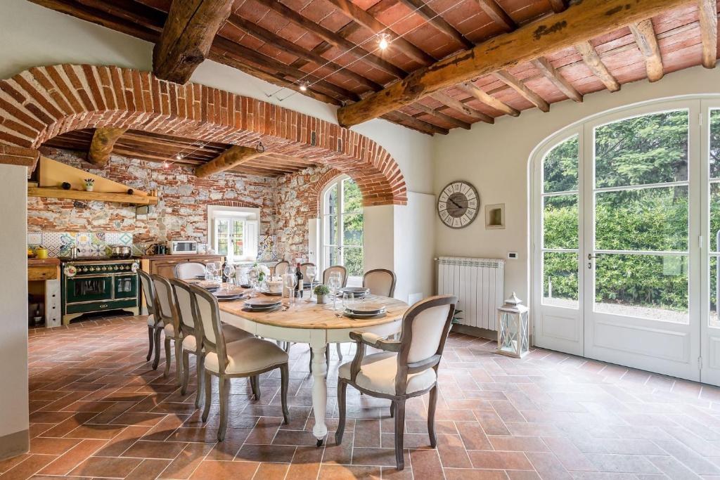 une cuisine et une salle à manger avec une table et des chaises dans l'établissement Villa Sul Fiume Romantic Farmhouse with Pool, à Lucques