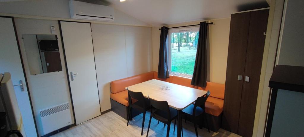 une pièce avec une table, des chaises et une fenêtre dans l'établissement Havre de paix dans un charmant campings, à La Boissière-de-Montaigu