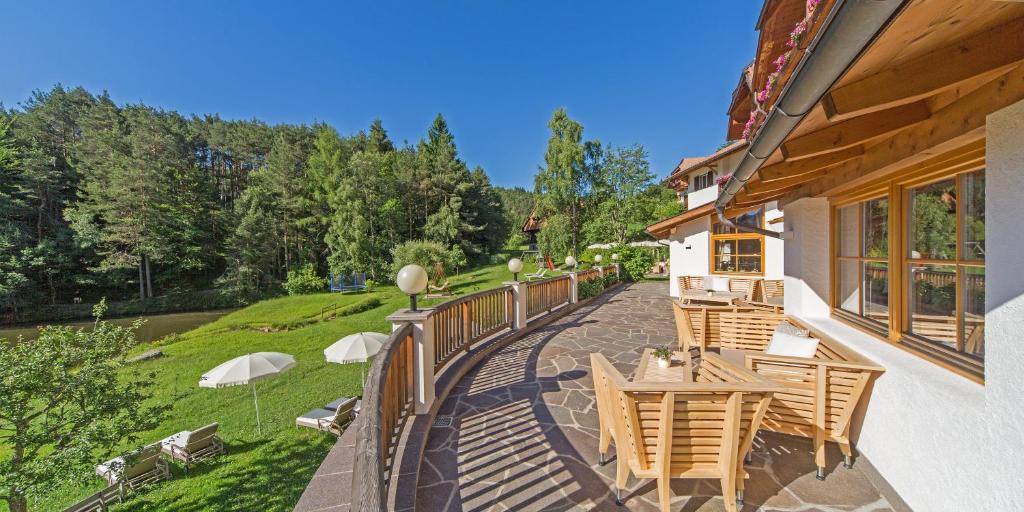 d'une terrasse avec des chaises et des tables sur un balcon. dans l'établissement Hotel Weihrerhof, à Soprabolzano