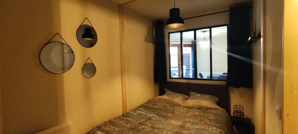 une chambre avec un lit et des miroirs au mur dans l'établissement Appart 4-6 pers au pied des pistes toutes saisons, à Molines-en-Queyras