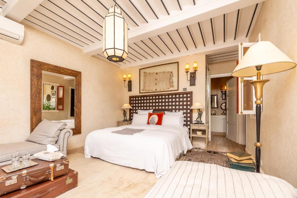 une chambre avec un grand lit blanc et un canapé dans l'établissement Indian Palace, à Marrakech 37 autres photos
