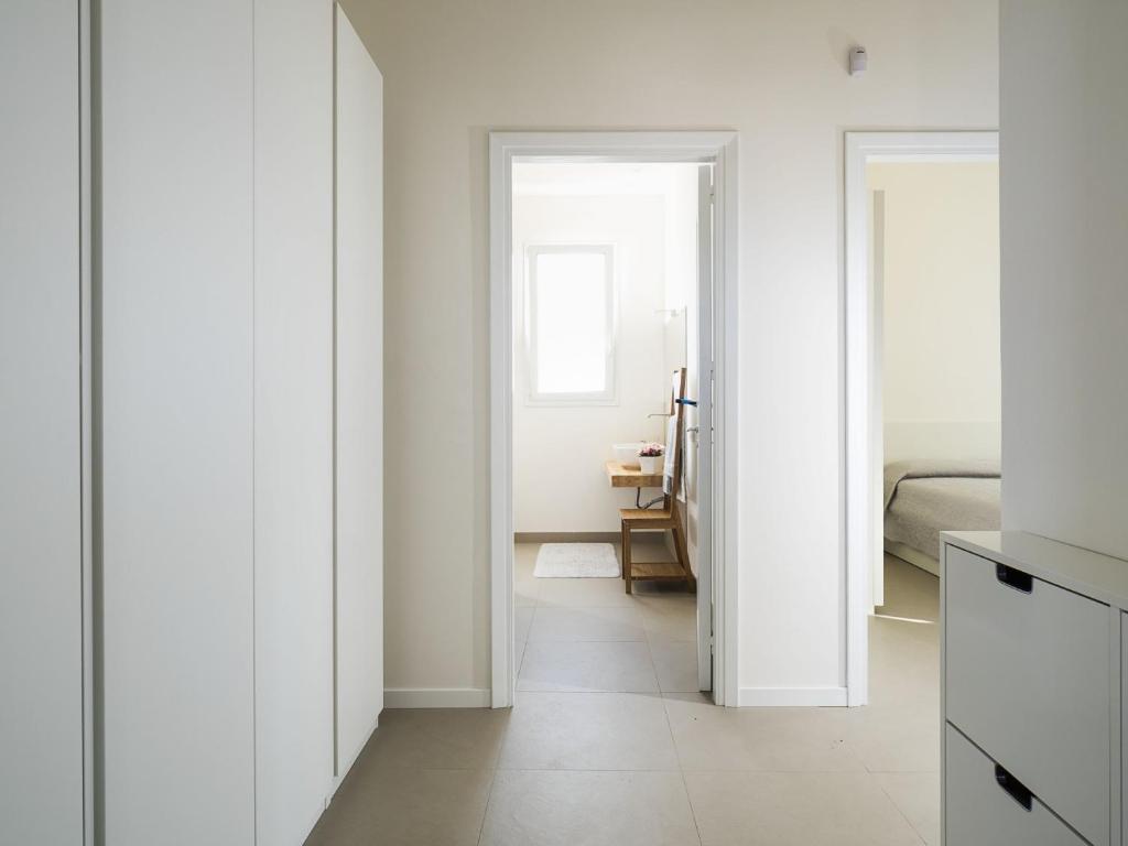 un couloir aux murs blancs et une chambre avec un lit dans l'établissement Villa Rita, à Marsala