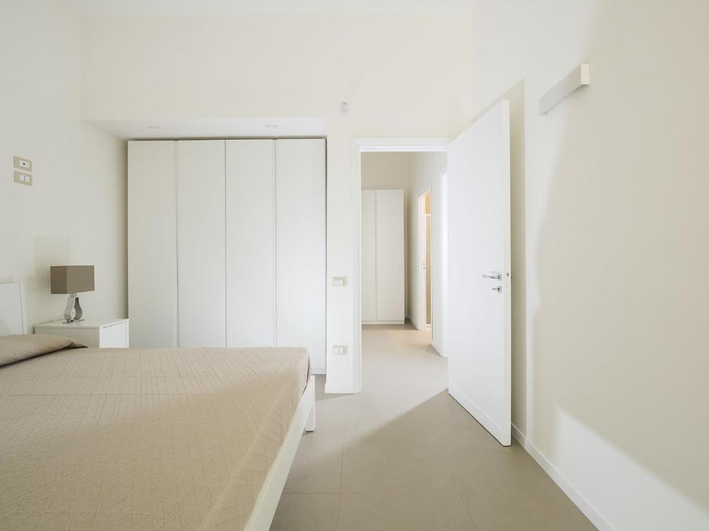 - une chambre avec des murs blancs, un lit et une porte dans l'établissement Villa Rita, à Marsala