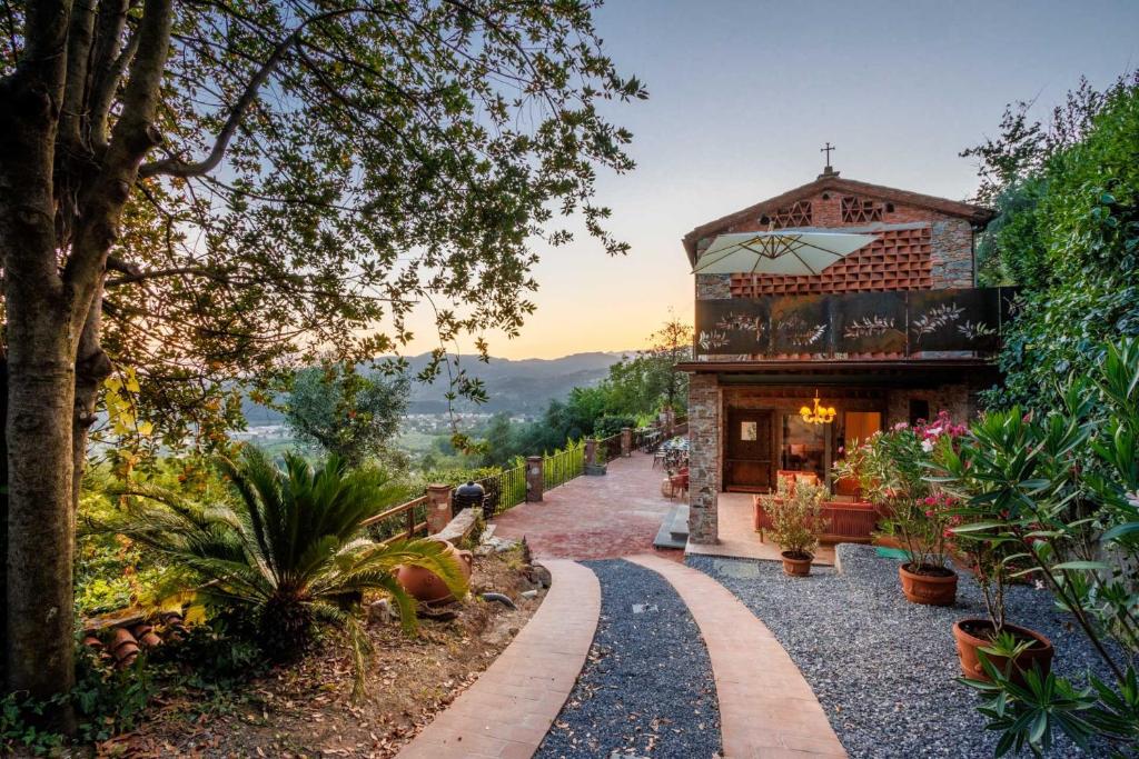 une maison avec un chemin menant à un bâtiment dans l'établissement Villa Alice, panoramic stone farmhouse to sleep 10, à Lucques