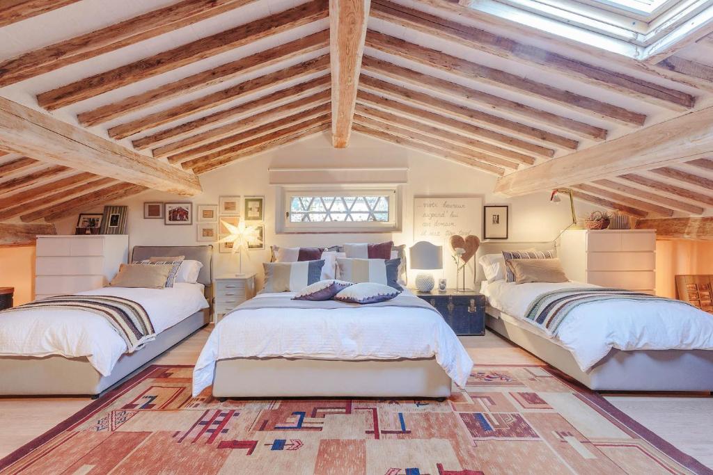 Cette chambre spacieuse dispose de 2 lits et de plafonds en bois. dans l'établissement Villa Label, when creativity meets style in endless romanticism, à Corsanico-Bargecchia