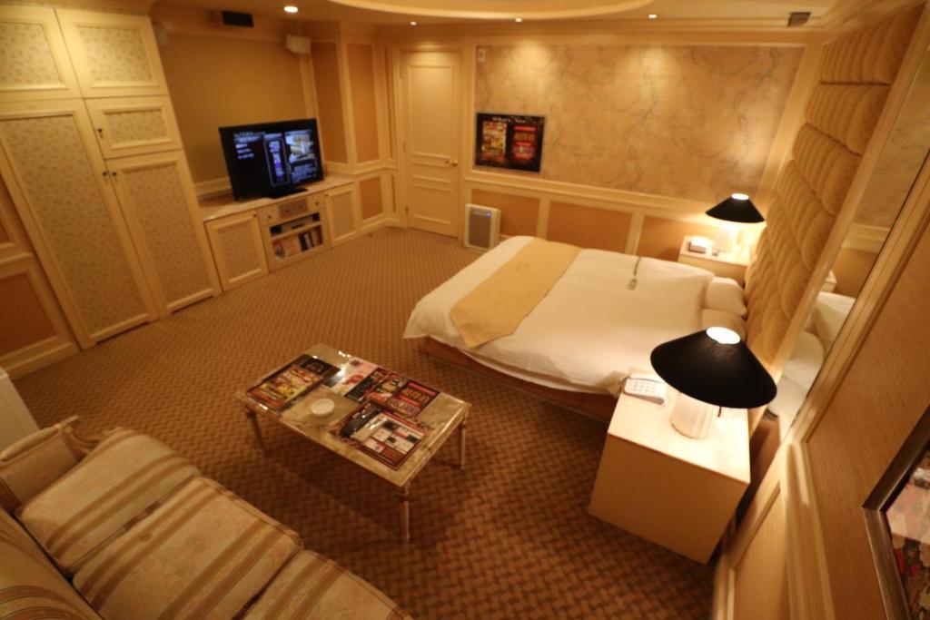une chambre d'hôtel avec un lit et un canapé dans l'établissement ホテルシエル, à Himeji