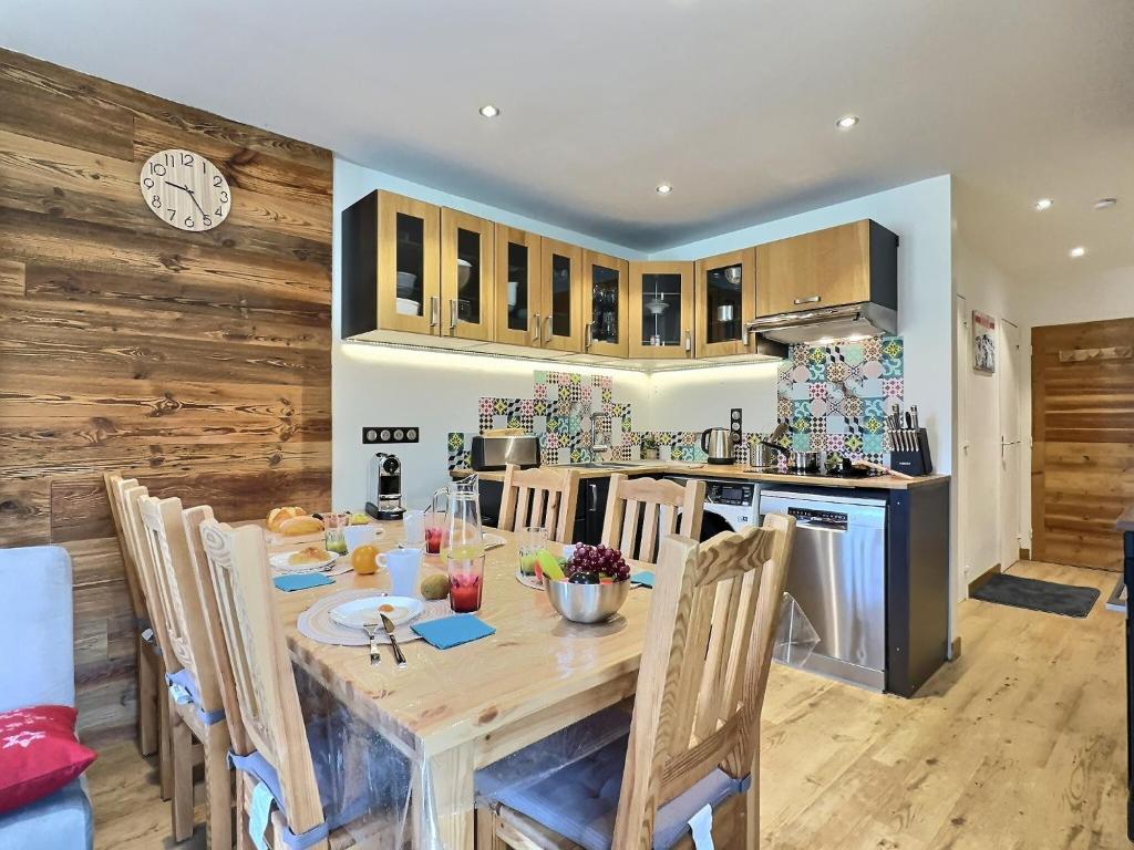 une cuisine et une salle à manger avec une table et des chaises en bois dans l'établissement Appartement 6 personnes avec Parking Couvert - 1 chambre - 4 lits - Netflix & wifi haut débit, à Tignes