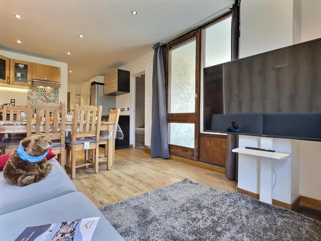 - un chien assis sur un canapé dans le salon dans l'établissement Appartement 6 personnes avec Parking Couvert - 1 chambre - 4 lits - Netflix & wifi haut débit, à Tignes