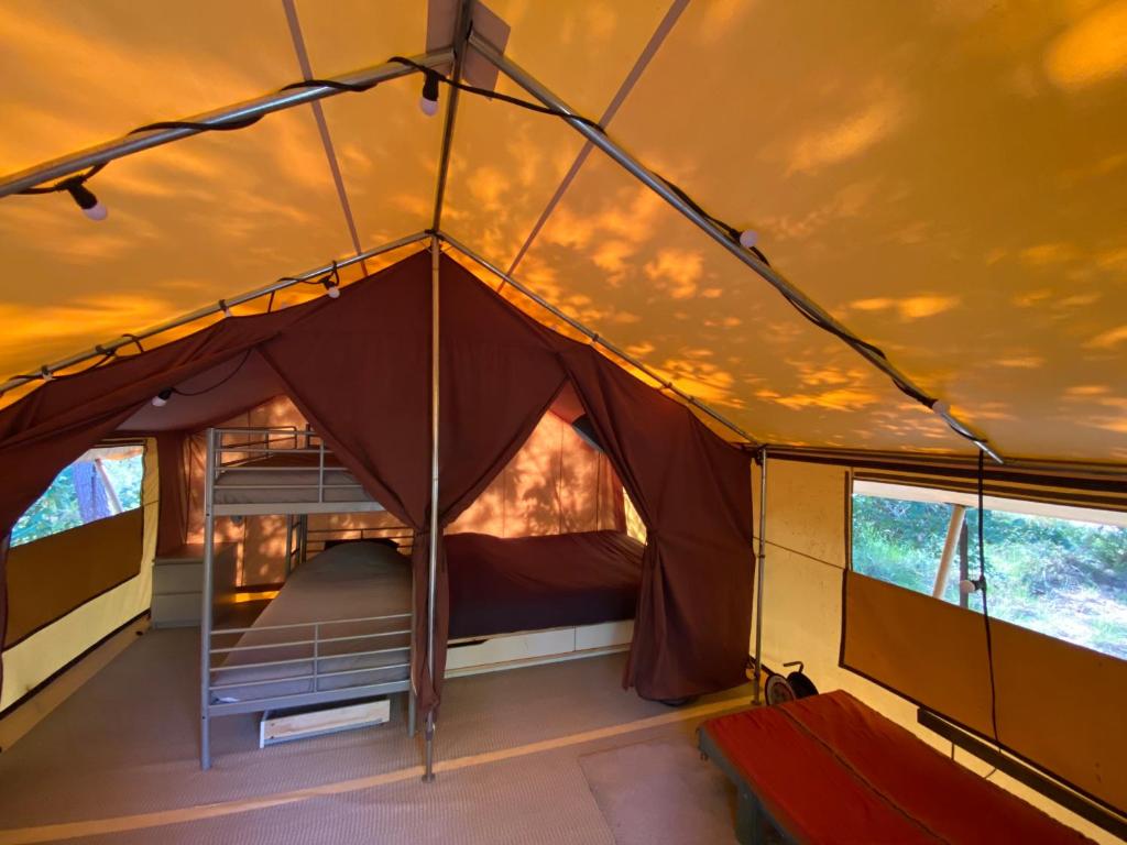 Un ou plusieurs lits dans un hébergement de l'établissement Camping la Kahute - Tente lodge au coeur de la forêt