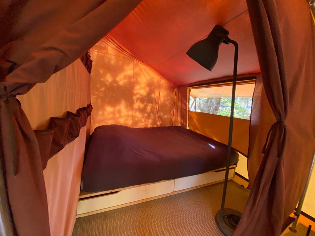 Un ou plusieurs lits dans un hébergement de l'établissement Camping la Kahute - Tente lodge au coeur de la forêt