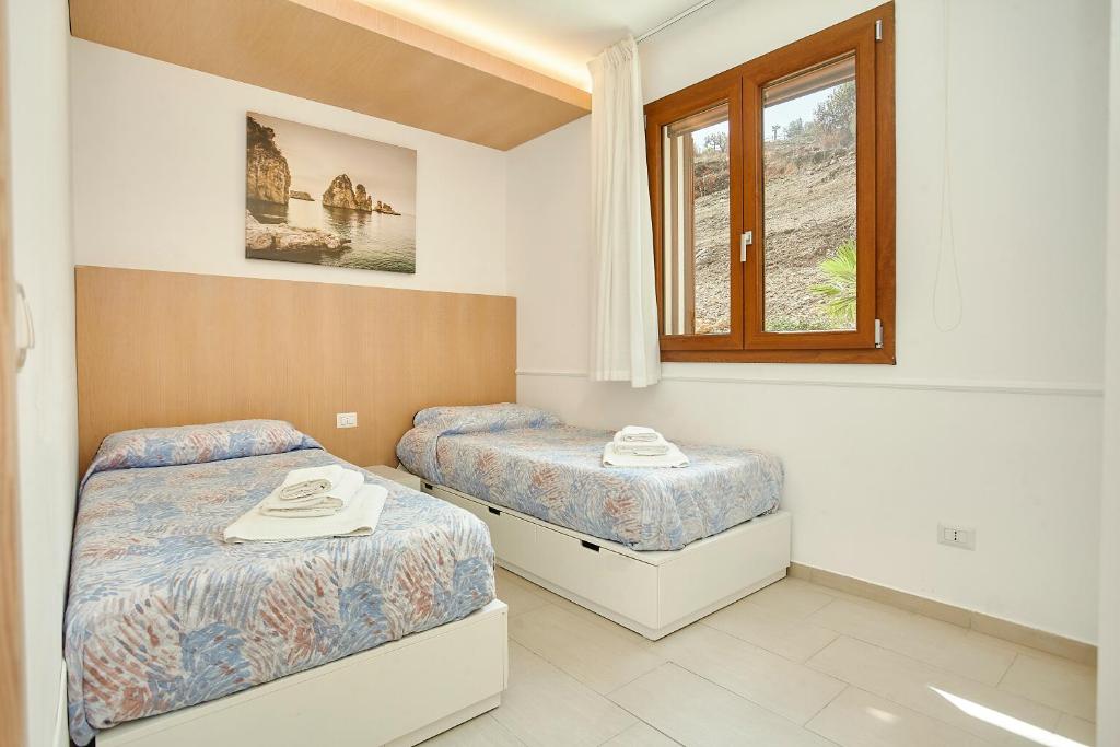 une chambre avec deux lits et une fenêtre dans l'établissement Villa dell'Artista, à Scopello 25 autres photos