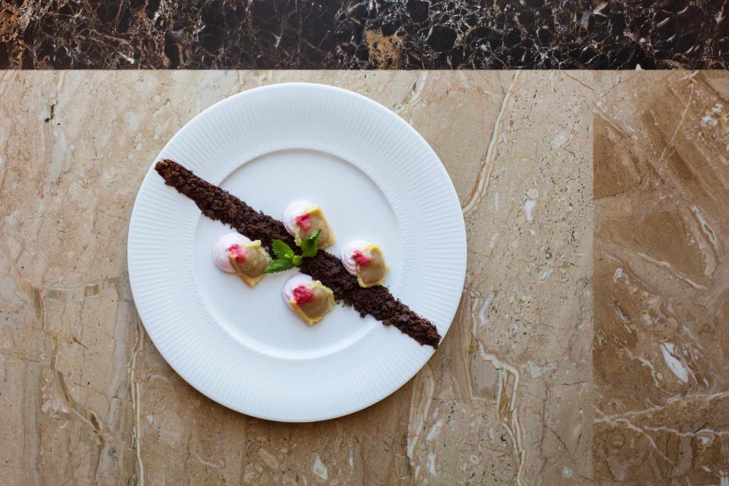 une assiette blanche avec de la nourriture sur une table dans l'établissement Spiagge San Pietro, a charming & relaxing resort, à Castiadas