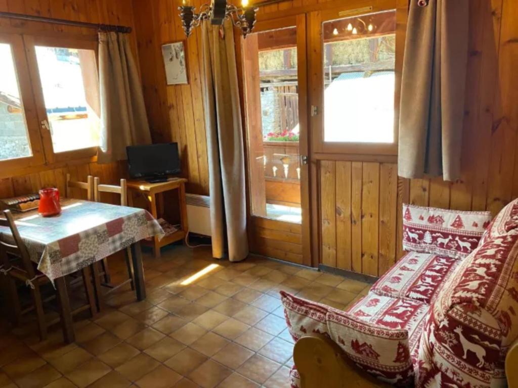 une pièce avec une table et un canapé et une table et une fenêtre dans l'établissement L'edelweiss, à La Plagne Tarentaise 6 autres photos