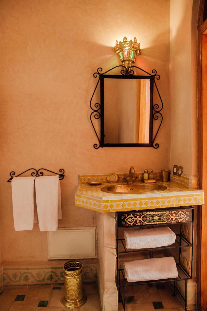 une salle de bain avec un lavabo, un miroir et des serviettes dans l'établissement Riad Bensaid, à Marrakech