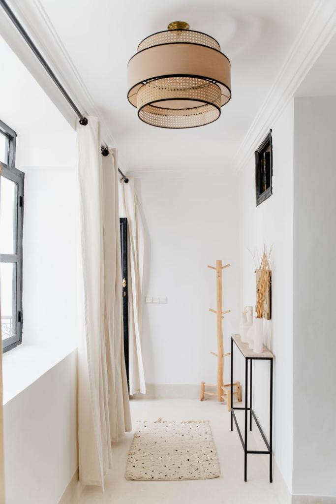 un salon avec un plafond blanc et un lustre dans l'établissement Riad 27 & SPA entièrement privatisé, à Marrakech