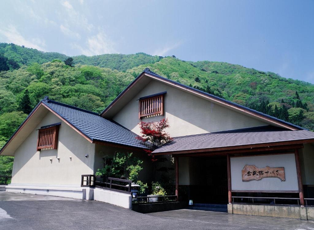 un bâtiment blanc avec une montagne en arrière-plan dans l'établissement Kinseikan Seseragi, à Minakami