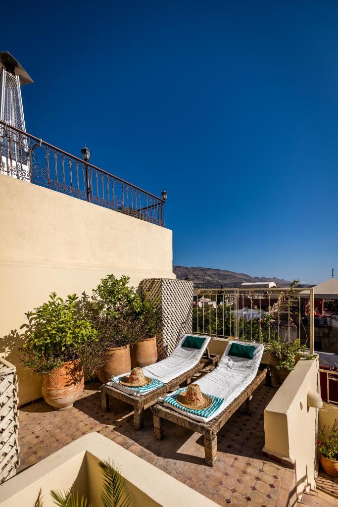 un patio avec une table et des chaises sur un balcon dans l'établissement Riad Tizwa Fes, à Fès