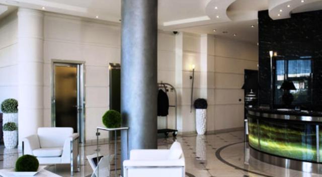 un hall avec des chaises blanches et un pilier dans un bâtiment dans l'établissement Gabri Park Hotel, à San Salvo