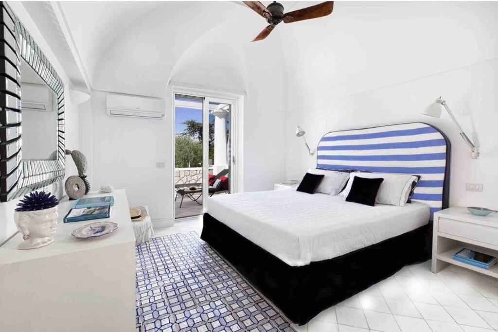 une chambre blanche avec un lit et un balcon dans l'établissement Luxury central Villa with pool and privacy, à Anacapri