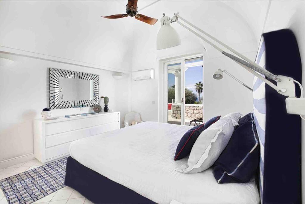 une chambre avec un lit et un ventilateur de plafond dans l'établissement Luxury central Villa with pool and privacy, à Anacapri 39 autres photos