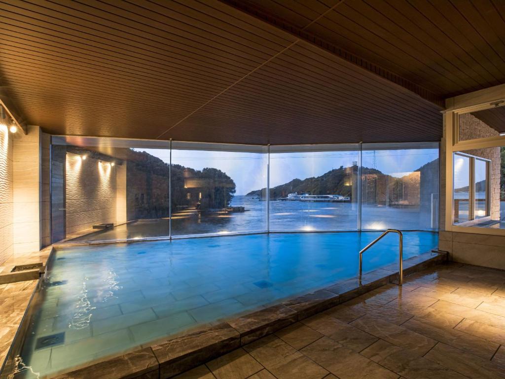 une grande piscine avec vue sur l'eau dans l'établissement Ooedo Onsen Monogatari Premium Toba Saichoraku, à Toba