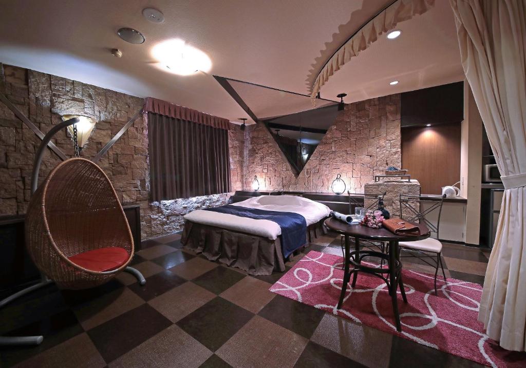 une chambre avec un lit, une table et une chaise dans l'établissement Hotel Mio Seki Adult Only, à Mukumoto
