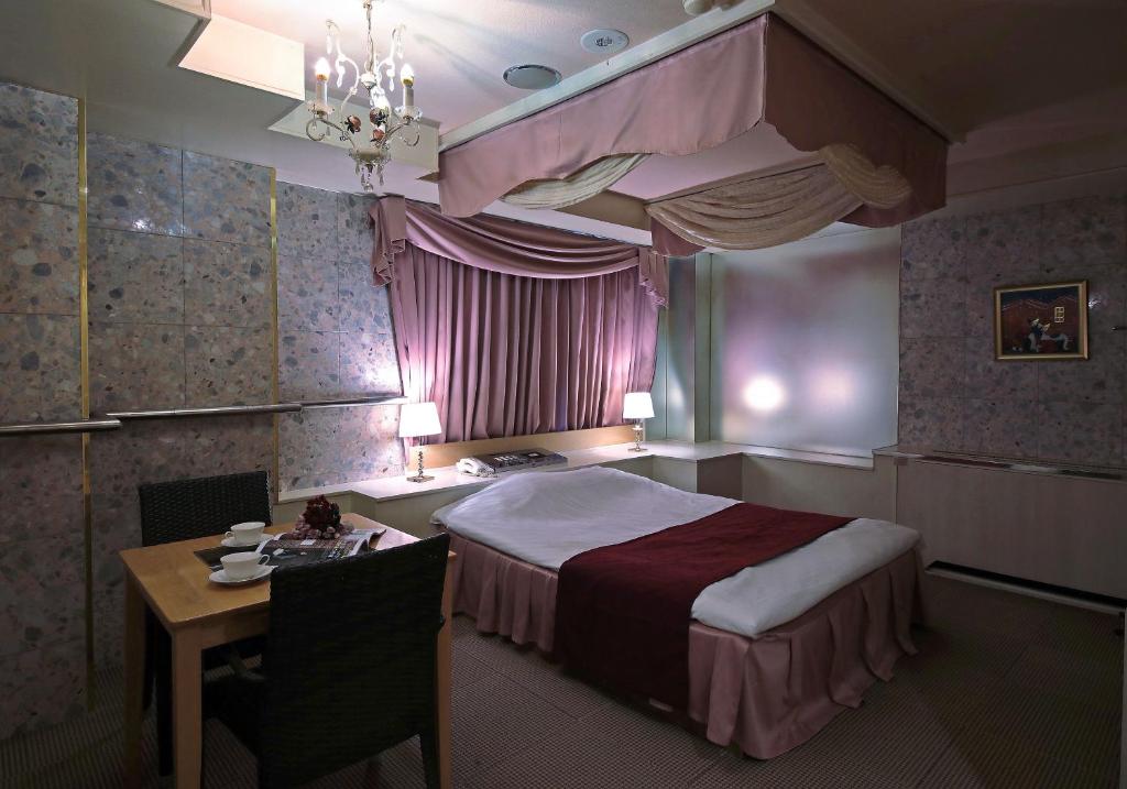 une chambre avec un lit et une table et une table et une chaise dans l'établissement Hotel Mio Seki Adult Only, à Mukumoto 9 autres photos
