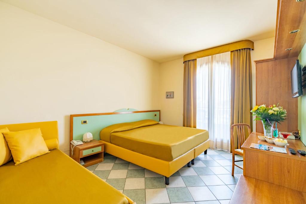 une chambre d'hôtel avec deux lits et une fenêtre dans l'établissement Hotel Villa Elena, à Tortoreto Lido