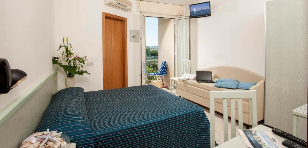 une chambre avec un lit et un bureau avec un ordinateur portable dans l'établissement Hotel leonardo, à Cattolica