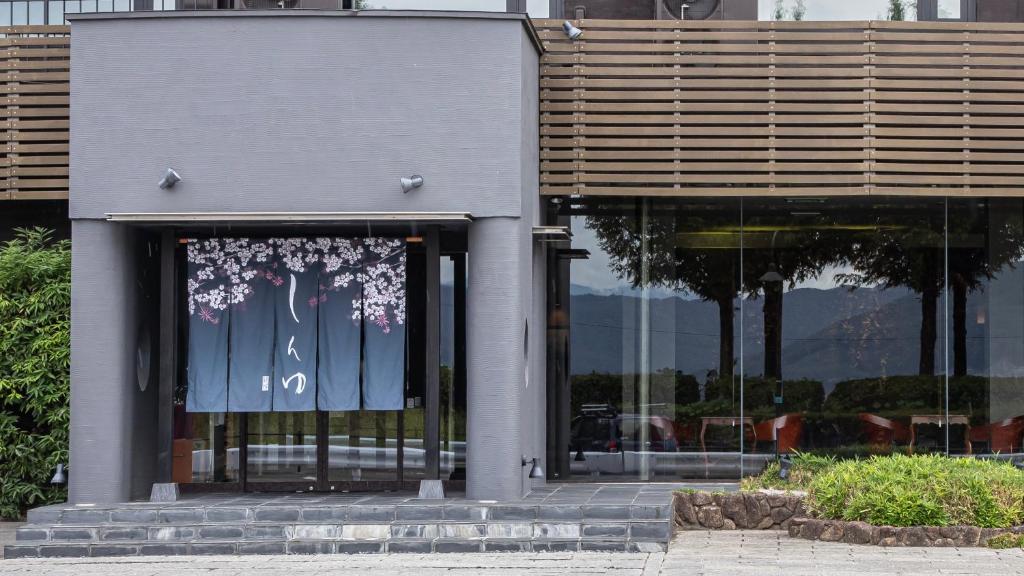 un bâtiment avec une porte vitrée avec des fleurs dessus dans l'établissement Kamisuwa Onsen Shinyu, à Suwa