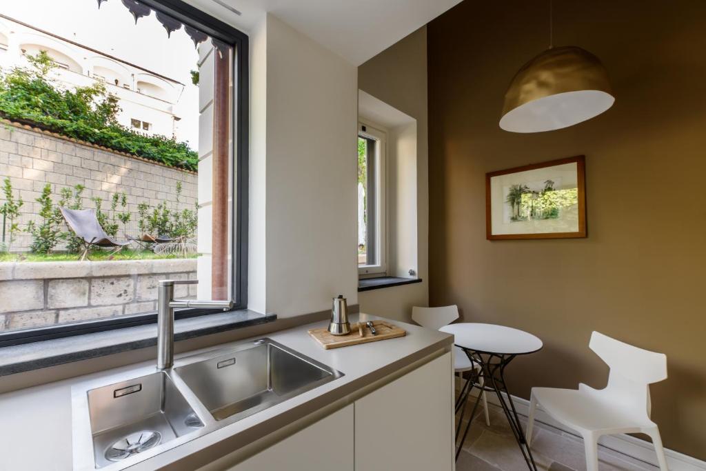 une cuisine avec un évier et une fenêtre dans l'établissement Parco dei Principi, à Sorrente