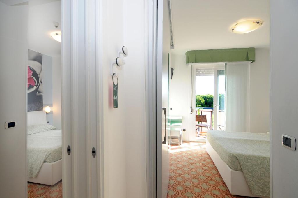 - une chambre avec un lit et une porte menant à une pièce dans l'établissement Hotel Oliver, à Caorle 128 autres photos