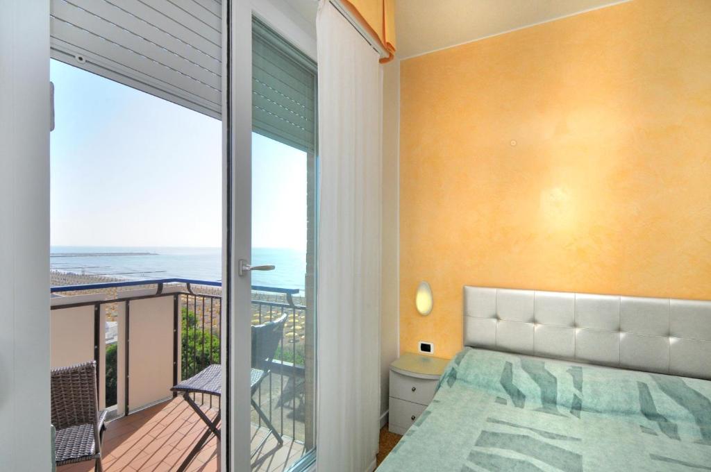 une chambre avec un lit et un balcon avec l'océan dans l'établissement Hotel Oliver, à Caorle