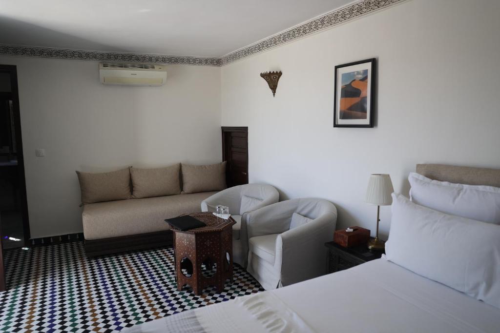 une chambre d'hôtel avec un lit et un canapé dans l'établissement Riad Batchisarai, à Fès