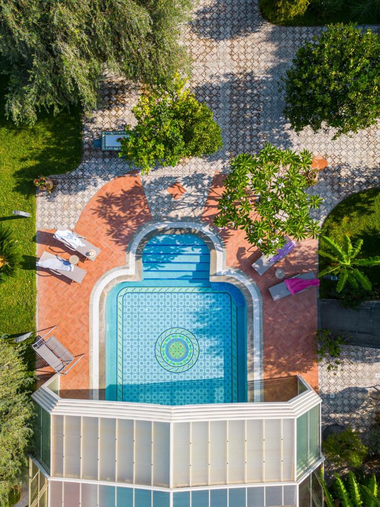 une vue aérienne d'une piscine dans un jardin dans l'établissement Villa Rita Taormina, à Taormine