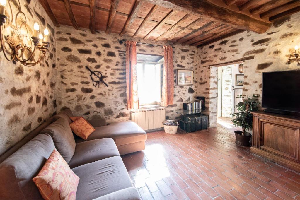 un salon avec un canapé et une télévision dans l'établissement Villa Iris with Swimming Pool, à Capannori