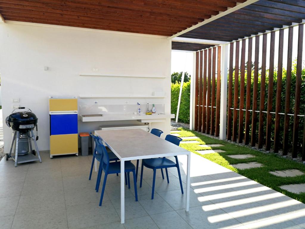 une cuisine extérieure avec une table et des chaises sur une terrasse dans l'établissement Villa Ametista, à Alcamo